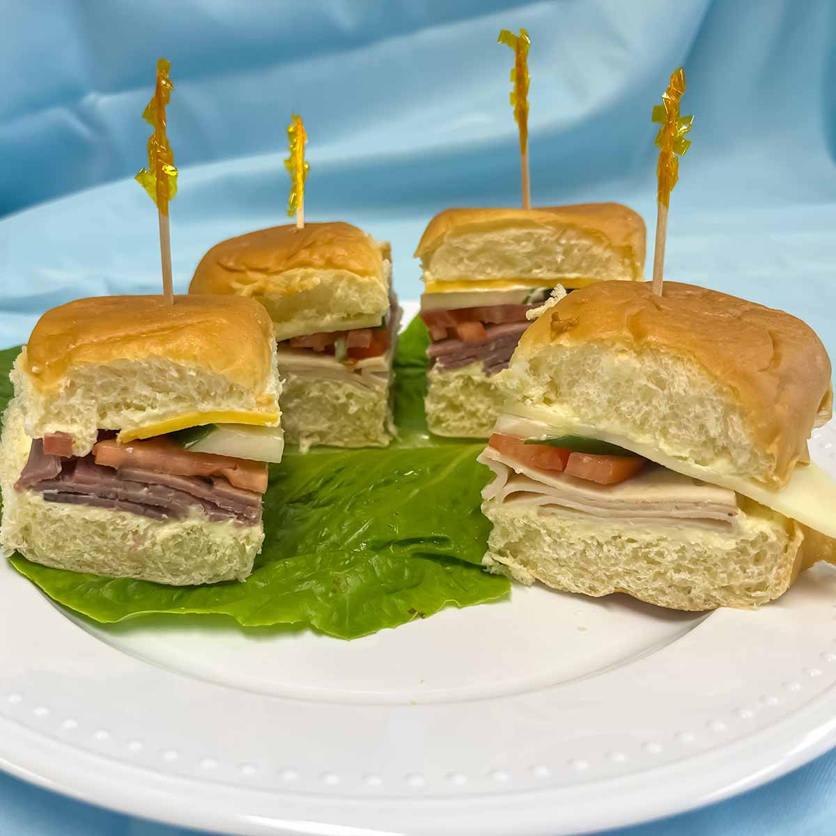 4 finger sandwiches with roast beef and cheddar, turkey and provolone or ham and swiss, tomato, lettuce, cucumbers or pickles on Hawaiian sweet rolls.